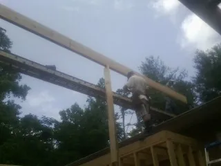 Carpenter setting a ridge beam over a new addition frame — Ice Dam Removal by Roofing Brothers in Maple Heights