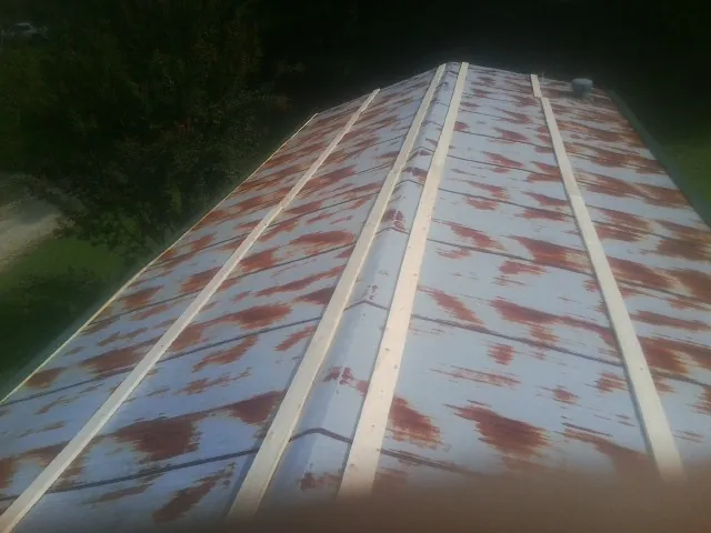 Rusted metal roof panels with new wood purlins before replacement — Storm Damage Roof Repair in Maple Heights by Roofing Brothers