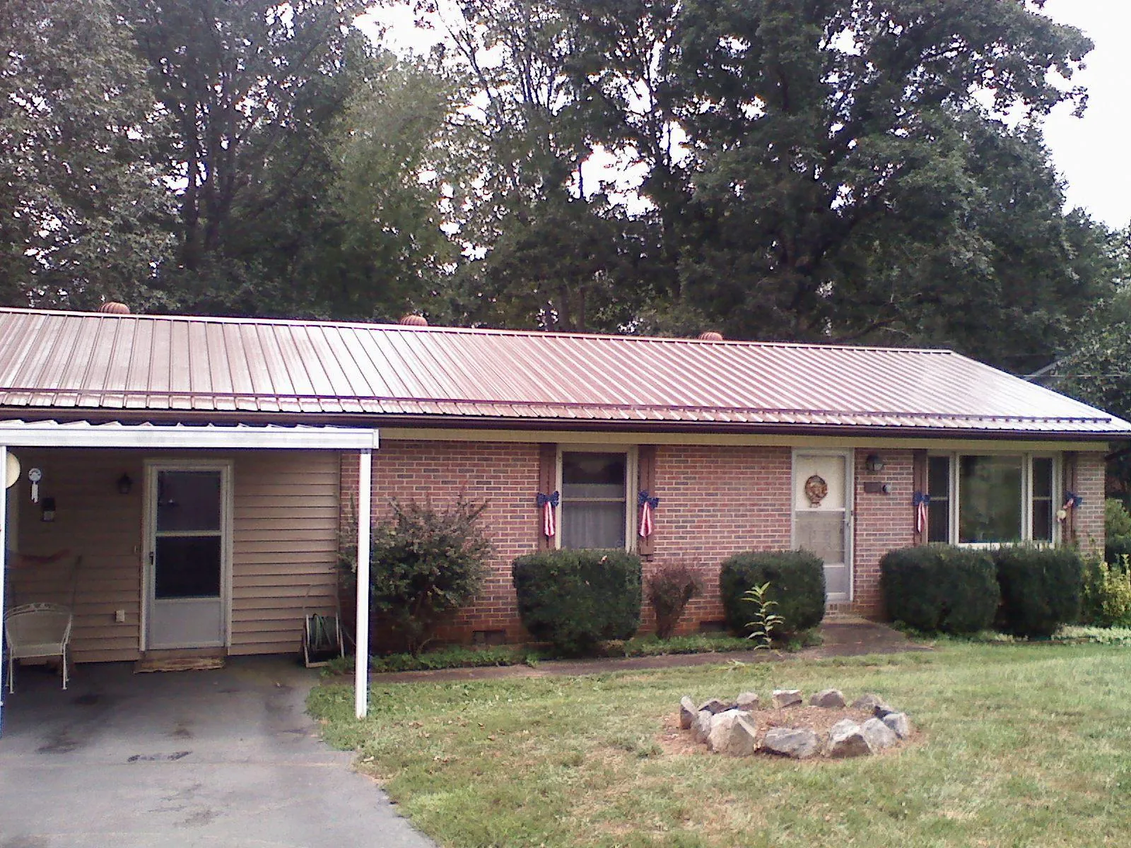 Bronze metal roof and carport on a brick ranch home — Roof Repair work by our crew in Maple Heights