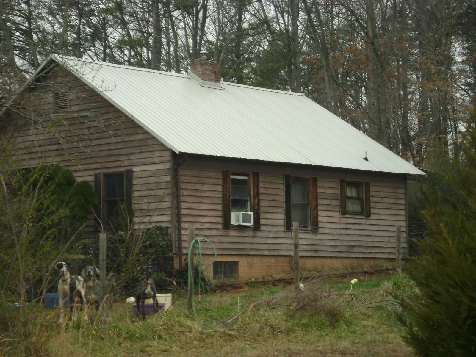 White metal roof on an old wood sided farmhouse, from a Metal Roof Installation job in Maple Heights